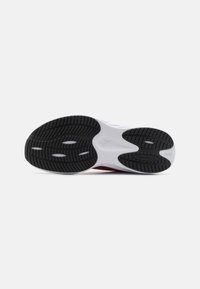 Svart-hvitt såle av sneakers med spor, riller og sirkulære mønstre for grep. "PROTREAD"-merking synlig på sålen.