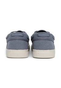 Blaue Leinensneaker mit strukturiertem Finish, ausgestattet mit einem Niedrigschnitt-Design, einer leichten Gummisohle und zwei hinteren Schlaufen für ein einfaches Anziehen.