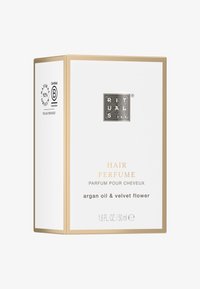 Packaging di profumo per capelli in una scatola bianca con accenti dorati. Il testo include "profumo per capelli", "olio di argan e fiore di velluto" e loghi di certificazione.