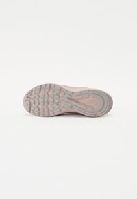 Sole di scarpa atletica Skeletal di colore grigio chiaro con accenti rosa, caratterizzata da un motivo battistrada testurizzato per aderenza e stabilità.