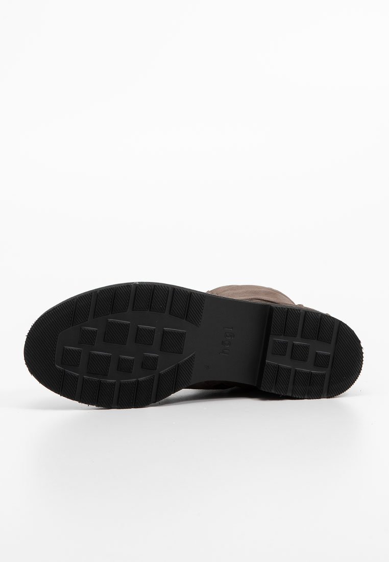 Semelle en caoutchouc noir avec un motif texturé, conçue pour l'adhérence. La tige est en matériau marron lisse. Construction robuste pour plus de durabilité.