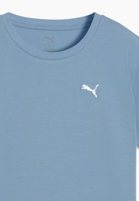Lichtblauwe katoenen T-shirt met een ronde hals, korte mouwen en een witte geborduurde logo op de linkerborst. Gladde textuur.