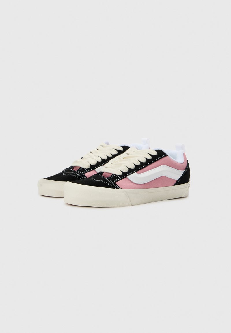 Zwarte en roze suède sneakers met witte accenten, ronde neus, platte rubberen zool en contrasterende stiksels. Heeft een klassiek vetersluitingsontwerp.