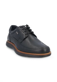 Zapato de cuero negro con punta redonda, diseño de cordones y forro textil. Presenta una suela de goma color marrón claro con un sutil detalle de costura.
