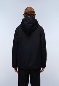 Sort hættejakke med en let struktureret overflade, løs pasform og justerbare snore i hætten. Har udvendige lommer og en afslappet silhuet.