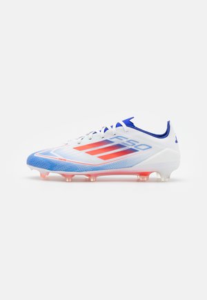 Scarpa da football in bianco, blu e corallo, con tomaia testurizzata, design a tre strisce prominenti e tacchetti traslucidi.