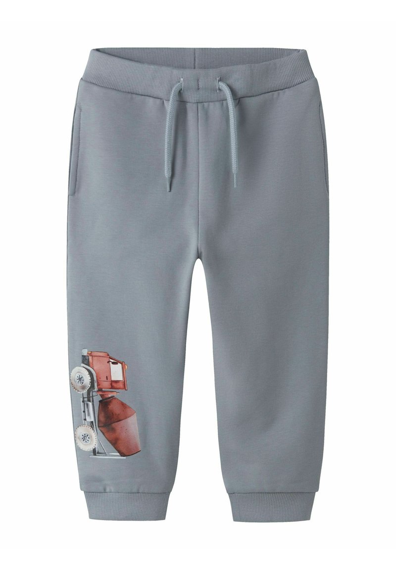Grå sweatpants med dragsko i midjan, med framfickor och ett tryckt mönster av ett byggverktyg på vänster ben.