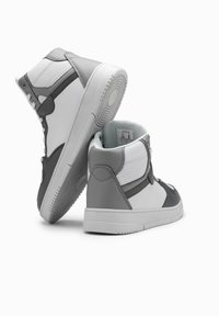 Des baskets montantes en cuir blanc et gris avec un design texturé, un col rembourré et une semelle en caoutchouc présentant un motif de traction circulaire.