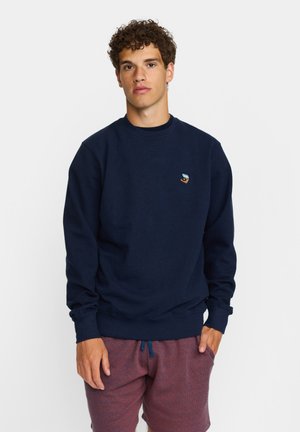 Marineblauer Pullover aus weichem Stoff, mit Rundhalsausschnitt und gerippten Bündchen. Kleines mehrfarbiges Logo auf der linken Brustseite.