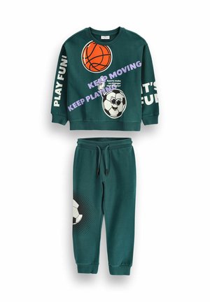 Ciemnozielona dziecięca bluza i spodnie z grafiką koszykówki i piłki nożnej oraz motywującymi sportowymi frazami w białym i fioletowym tekście.