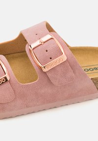 Rosa faux semsket sandal med to justerbare buckler i rosegull, et formet korkfotbed og teksturert såle for godt grep.