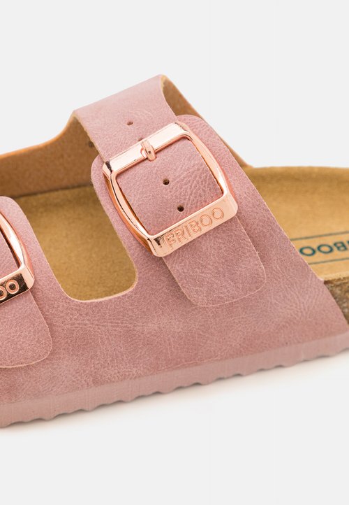 Ružová sandála z faux semišu s dvoma nastaviteľnými prackami v ružovom zlate, tvarovanou korkovou stielkou a textúrovanou podrážkou pre lepšiu priľnavosť.