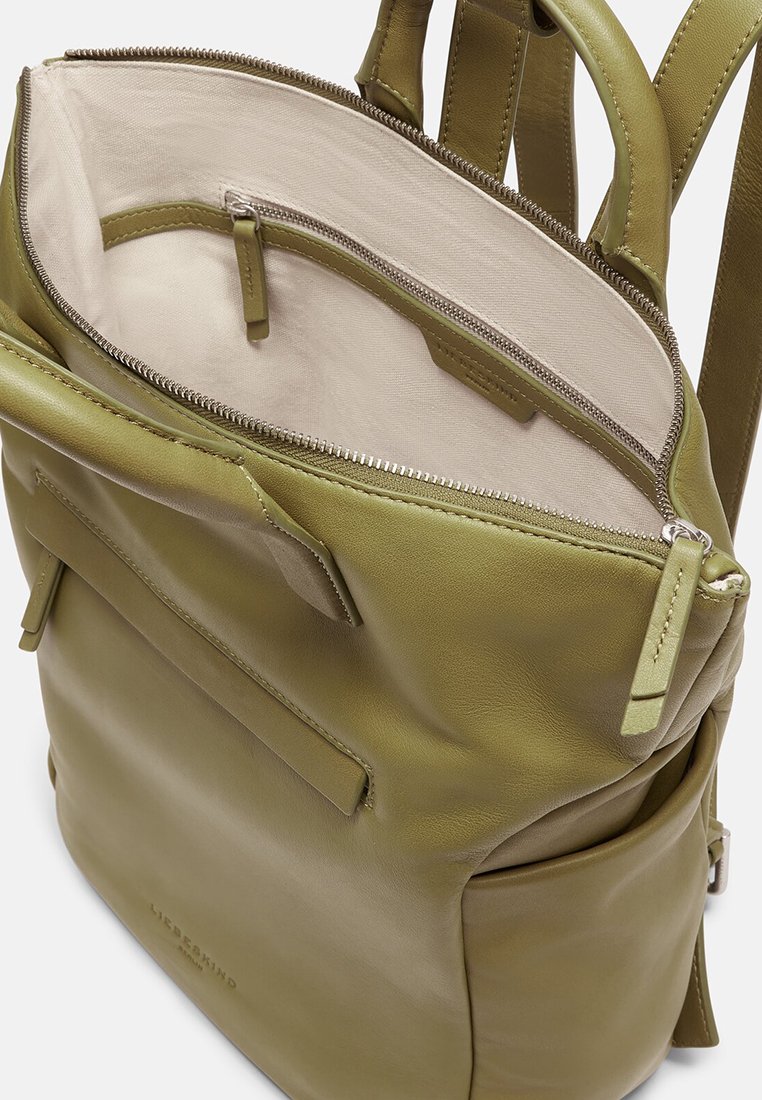 Grüner Leder-Rucksack mit weicher Textur, ausgestattet mit einem Reißverschluss, Innenfächern und einer äußeren Fronttasche für einfachen Zugang.