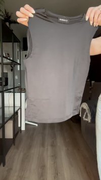 Szürke ujjatlan felső sima anyagból, kerek nyakkivágással és egyenes aljjal. Címke mutatja a "evenwood" márkanevet.