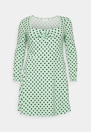 Vestido de manga longa verde menta com bolinhas pretas, apresentando um decote quadrado e detalhes franzidos na frente, confeccionado em tecido macio.