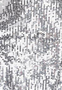 Ezüst és fekete flitteres anyag, amely tükröződő, texturált felületű, kör alakú formákkal és különböző méretekkel, csillogó mintázatot alkotva.