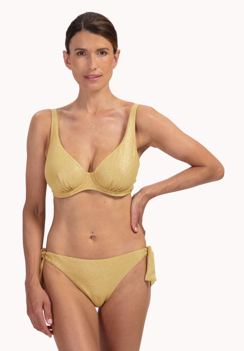 Conjunto de bikini amarillo con acabado texturizado y acanalado. El top tiene tirantes anchos y escote pronunciado; la parte inferior se ata en las caderas.