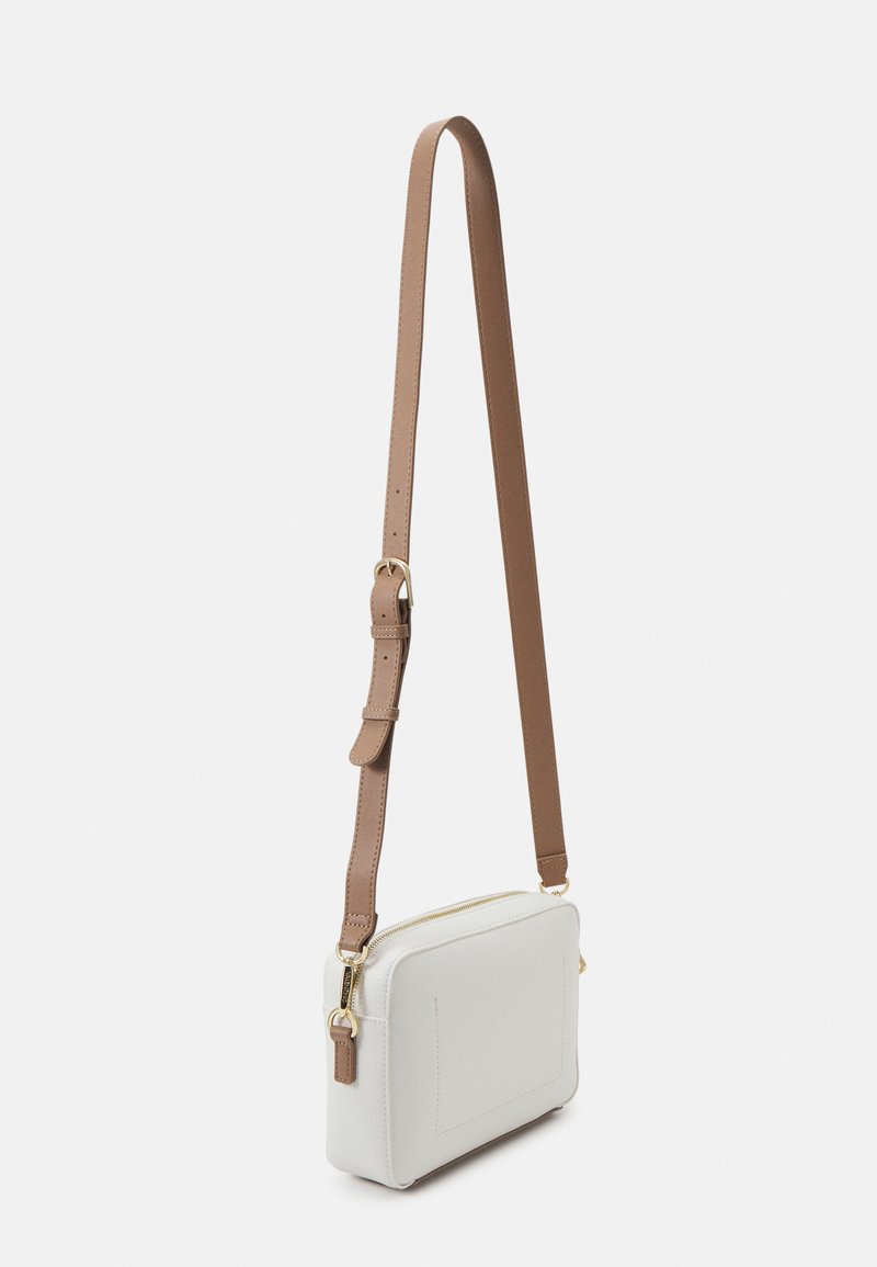 Bolso cruzado en cuero texturizado blanco con forma rectangular, correa marrón, herrajes dorados y cierre de cremallera en la parte superior.