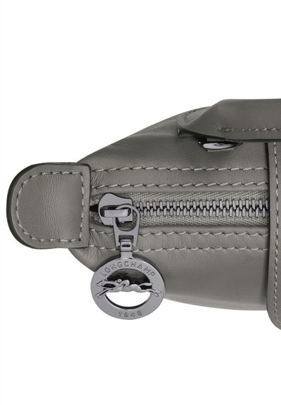 Gray leather bag with a zip closure, featuring stitched accents and a silver-tone logo charm with a rabbit design.