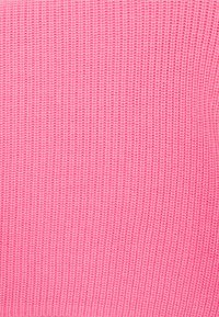 Rosa stickat tyg med ribbad textur; har jämnt fördelade linjer som skapar ett konsekvent mönster över ytan.