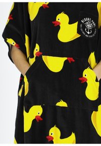 Loungewear in pile nero, con fantasia di anatre di gomma gialle e tasca frontale. Texture morbida, maniche corte e design a vestibilità larga.