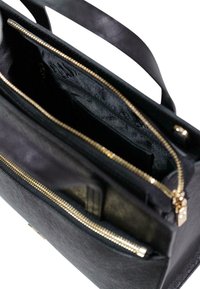 Borsa nera in pelle con superficie testurizzata, chiusura con zip dorata e un interno organizzato con una tasca separata per riporre gli oggetti.