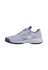 Light purple tennis shoes with a smooth material, mesh accents, and a rubber sole featuring a textured pattern. Logo visible on the side.