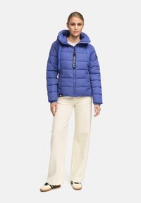 Opblaasjas in een levendig paarser kleur, met een capuchon, ritsluiting en verstelbare koordjes, gecombineerd met crèmekleurige wijde broek.