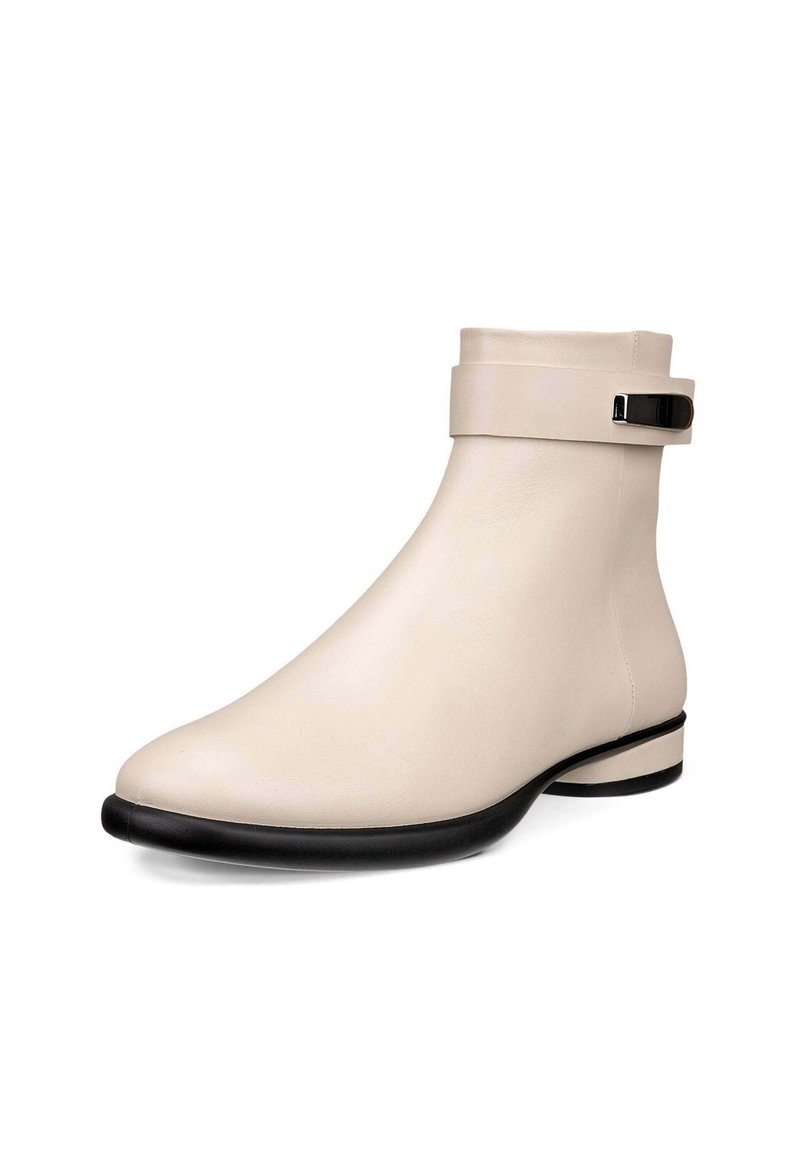 Beige Ankle-Boots aus glattem Leder, mit einem schwarzen Akzentriemen und einer flachen, schwarzen Sohle mit abgerundeter Zehenpartie.