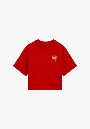 Sweat-shirt rouge à manches courtes avec poche avant et petit graphique blanc en spirale de soleil sur la partie supérieure gauche de la poitrine.