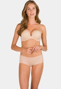 Beige naadloze beha met lichte padding en verstelbare bandjes, gecombineerd met bijpassende beige boyshorts. Soepele textuur en figuurvormend ontwerp.