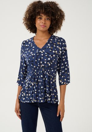 Blusa blu a fantasia con scollatura a V, maniche a tre quarti e vita elastica, realizzata in un tessuto morbido e leggero.