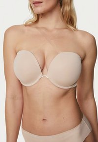 Naadloze, huidkleurige strapless beha met gladde, gevormde cups, beugelondersteuning en transparante, kleefstrips; naadloos ontwerp voor een betere pasvorm en comfort.