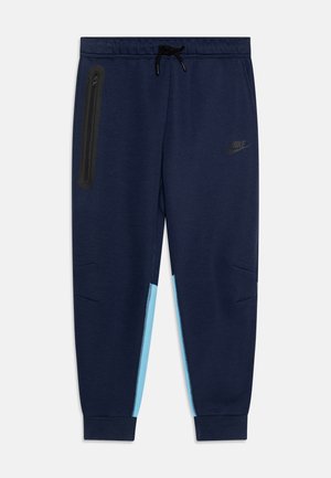 Pantalones de chándal de color navy con un bolsillo con cremallera negra y acentos laterales en azul claro. Cuentan con una cinturilla elástica con cordón y puños ajustados.