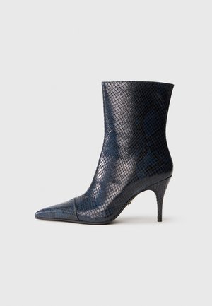 Čevlji do gležnja z ostrim nosom, izdelani iz sijajnega modrega umetnega kačjega usnja, s sleek obliko in tankim stiletto peto. Imajo teksturiran vzorec in gladke akcente.