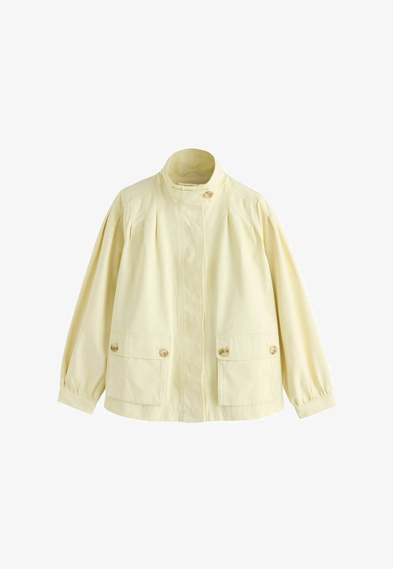 Bawełniana, jasnżółta kurtka z wysokim kołnierzem, plisowanym przodem, dwoma przednimi kieszeniami i zatrzaskami. Długie, lekko bufiaste rękawy.
