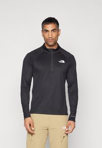 Zwarte long-sleeve top met een kwart rits en logo op de borst, gemaakt van lichtgewicht materiaal, ontworpen voor buitenactiviteiten.