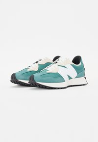 Sneaker in teal e bianco con tomaia in suede, dettagli texturizzati e suola ammortizzata con battistrada in gomma nera. Design classico con lacci.