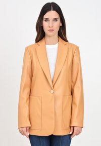 Blazer in finta pelle color beige con revers a punta, chiusura a un bottone e due tasche frontali. Texture liscia e vestibilità sartoriale.