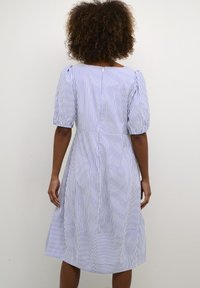 Light blue and white striped cotton dress with short puff sleeves, a defined waist, and a flowy skirt, featuring a back zipper closure.