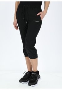 Pantaloni sportivi neri a metà gamba con vita regolabile e tasche laterali, caratterizzati dal logo "SWEDEMOUNT" in bianco sul davanti.