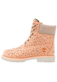 Stivale alla caviglia in pelle pesca con disegni a taglio, dettagli grigi, occhielli in metallo e suola bianca robusta. Logo impresso sul lato.