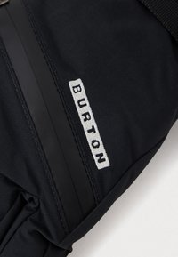 Manusi de schi Burton negre, cu un exterior din material textil, manșetă elastică și logo brodat alb. Textură netedă, cu detalii de cusătură întărită.