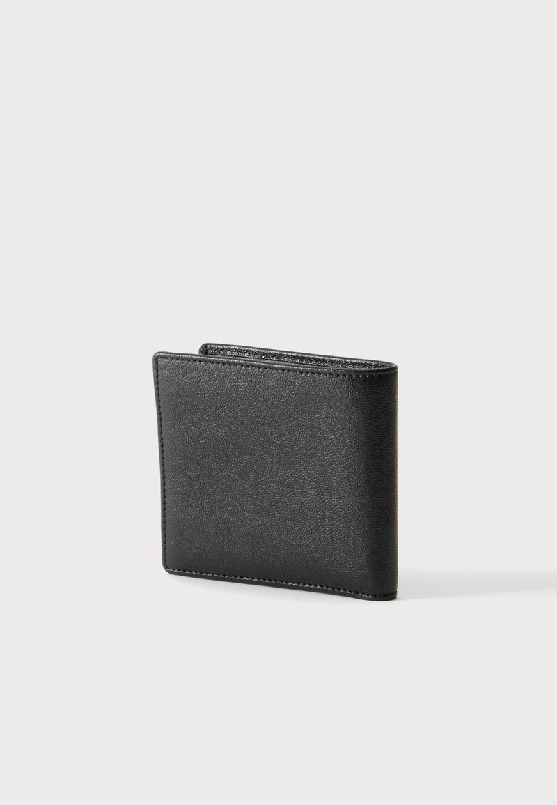 Black leather bifold wallet standing closed on a plain light background showing textured surface and stitched edges.