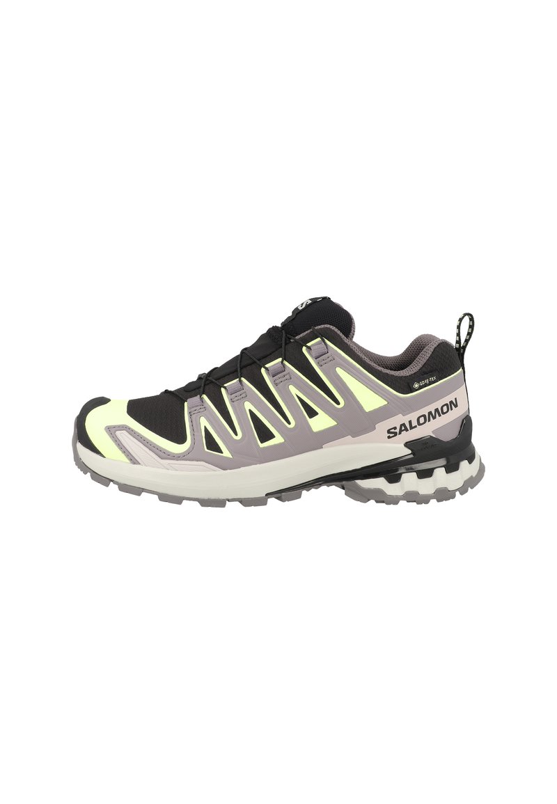 Scarpa sportiva nera e gialla con tomaia in mesh, dettagli sintetici, suola in gomma testurizzata e una linguetta sul tallone per facilitare l'uso.