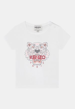 Biała koszulka z krótkim rękawem z grafiką twarzy tygrysa z napisem "KENZO PARIS" na czerwono poniżej wzoru. Materiał bawełniany, miękka w dotyku.