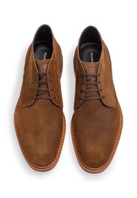 Braune Wildleder-Schnürschuhe mit glatter Oberfläche, runder Zehenpartie und hellbrauner Gummisohle. Merkmale sind minimale Nähte und ein klassisches Design.