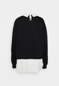 Sweat à capuche noir avec un col blanc et un ourlet superposé. Dispose d'une fermeture au dos et de manches tombantes. Tissu doux, coupe décontractée.