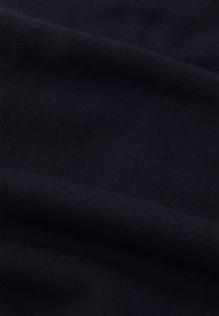 Tela de un azul marino oscuro con una textura suave y lisa. El material parece ligeramente aterciopelado, con variaciones sutiles en el tono. No hay patrones o diseños distintivos.