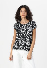 Svart og hvit zebra mønstrete kortermet skjorte, rund hals, myk tekstur, kombinert med lyse farge vide bukser.